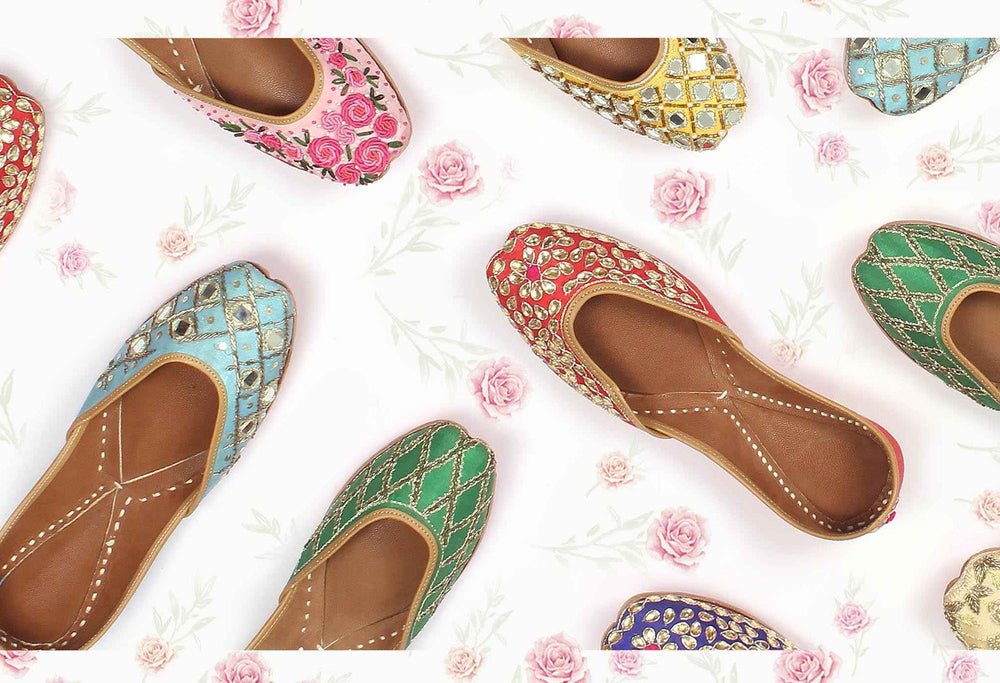 Colorful embroidered Punjabi Women Jutti flats on a floral background